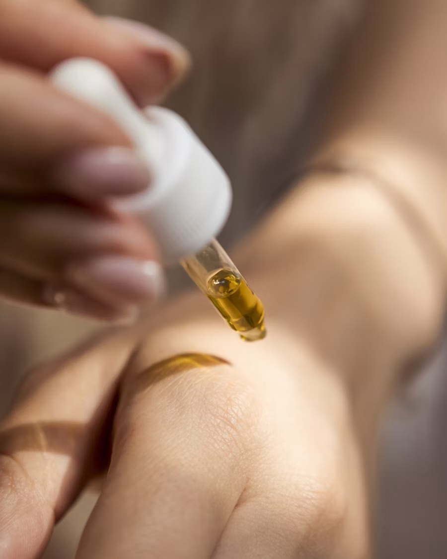 Tetes minyak CBD diteteskan ke kulit sebagai bagian dari rutinitas wellness