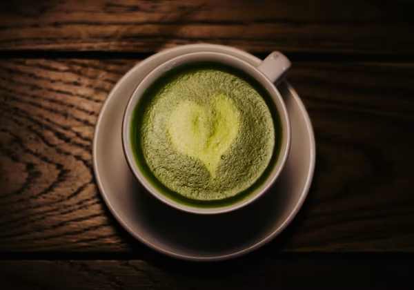 Segelas minuman hijau menyegarkan di atas meja kayu